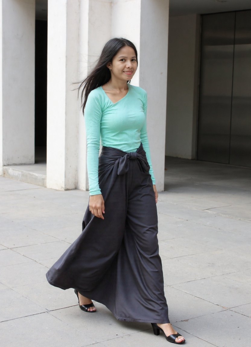 Full stride along architectural columns — the corridor stretches behind her, elevator receding